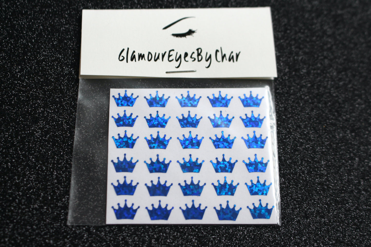 No need to go to the nail salon. Spice up your nails at home with these cute crown nail decals. They can be used on natural or acrylic nails. You can also apply them on top of regular or gel/shellac nail polish. These handmade decals can also be used for body art or any DIY project. Each pack contains 30 decals and is available in 6 different colours. Tip: Apply some of our glitter on your nails to really GLAMOUREYES your look.