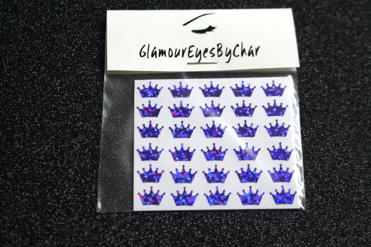 No need to go to the nail salon. Spice up your nails at home with these cute crown nail decals. They can be used on natural or acrylic nails. You can also apply them on top of regular or gel/shellac nail polish. These handmade decals can also be used for body art or any DIY project. Each pack contains 30 decals and is available in 6 different colours. Tip: Apply some of our glitter on your nails to really GLAMOUREYES your look.