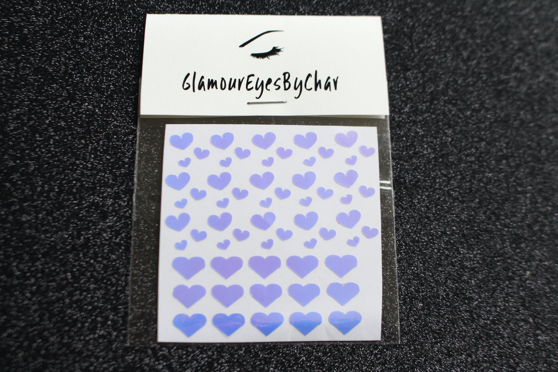 No need to go to the nail salon. Spice up your nails at home with these cute heart nail decals. They can be used on natural or acrylic nails. You can also apply them on top of regular or gel/shellac nail polish. These handmade decals can also be used for body art or any DIY project. Each pack contains 60 decals and is available in 4 different colours.  The pack also includes 4 different sizes so that you can mix and match.  Tip: Apply some of our glitter on your nails to really GLAMOUREYES your look.