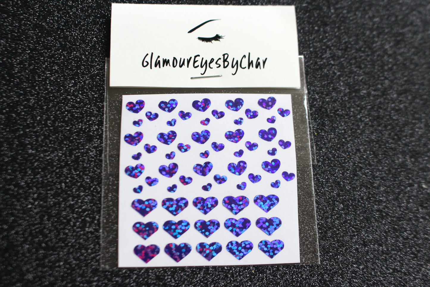 No need to go to the nail salon. Spice up your nails at home with these cute heart nail decals. They can be used on natural or acrylic nails. You can also apply them on top of regular or gel/shellac nail polish. These handmade decals can also be used for body art or any DIY project. Each pack contains 60 decals and is available in 4 different colours. The pack also includes 4 different sizes so that you can mix and match. Tip: Apply some of our glitter on your nails to really GLAMOUREYES your look.