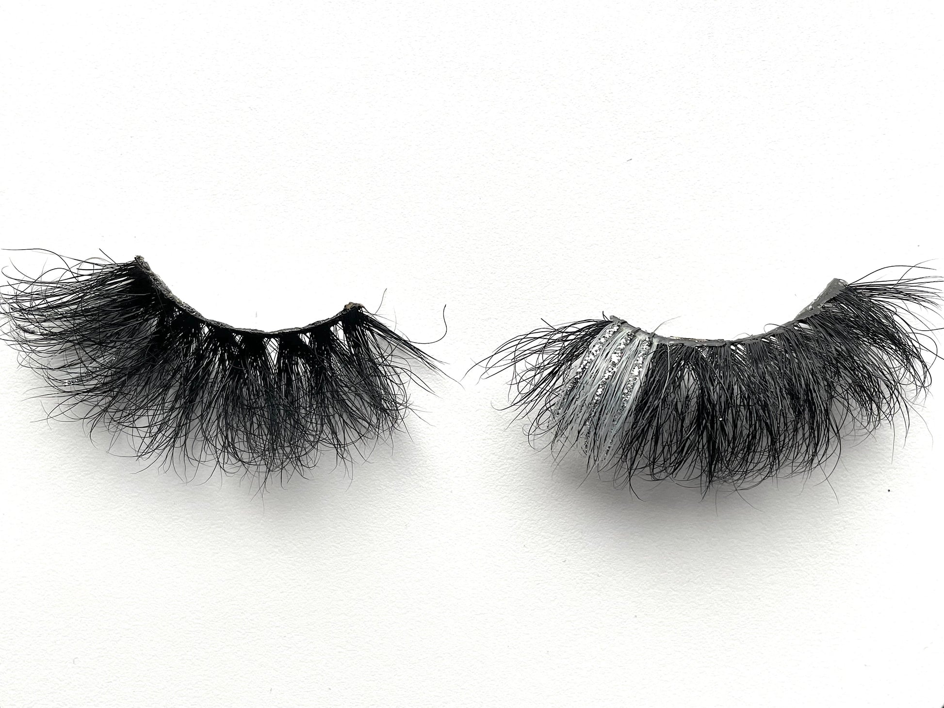 Stormy – 5D Premium Mink Lashes (25mm)
These 5D premium mink lashes are 25mm in length—dramatic, fluffy, lightweight, and comfortable to wear. A pop of silver and glitter on the outer corners adds extra sparkle and playfulness to your eyes. The flexible cotton lash band makes application a breeze.
Stormy lashes are designed to stand out at any event ⚡. They’re bold, eye-catching, and not for timid lash wearers. Each reusable pair can be worn up to 25 times with proper care.