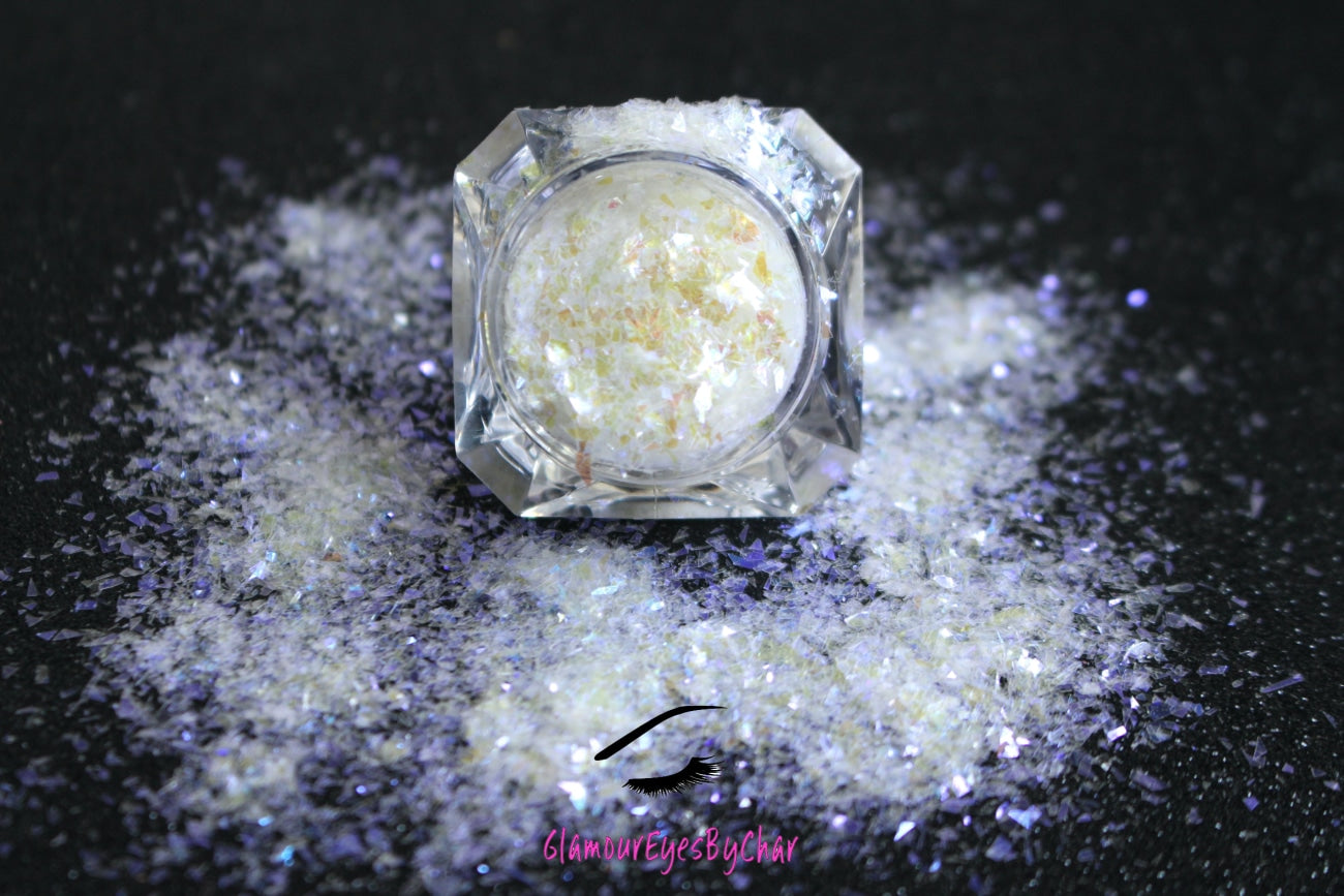 This glitter is called Angel's Kiss and is part of the cellophane glitter flakes collection. It consists of white iridescent glitter shards with purple reflects. Angel's Kiss is perfect for body and nail art, glitter slime, resin art or DIY projects. Comes in 5g jars only.
