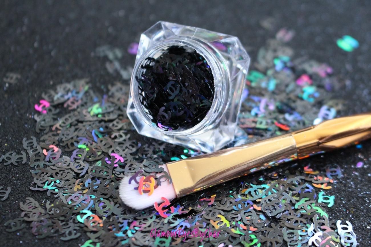 This glitter is called CC and is part of the shaped glitters collection. It consists of unique Chanel designer inspired holographic black CC letters. CC can be used for body and nail art or DIY projects. Available in 5g jars only.
