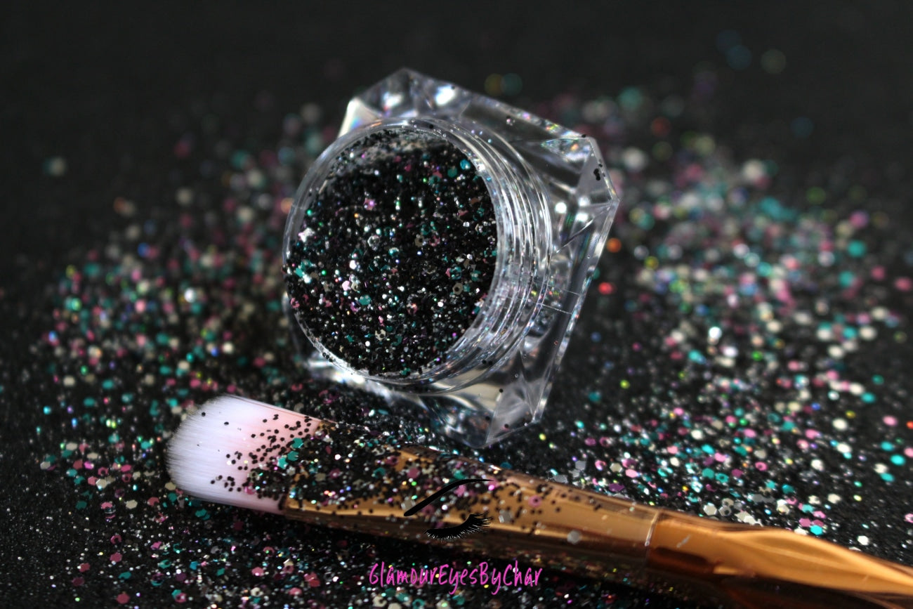 This glitter is called Drama Queen and is part of the chunky glitter collection. It consists of black holographic glitter with a multi-coloured sparkle. Drama Queen can be used for your face, body, hair and nails. Comes in 5g and 10g jars.