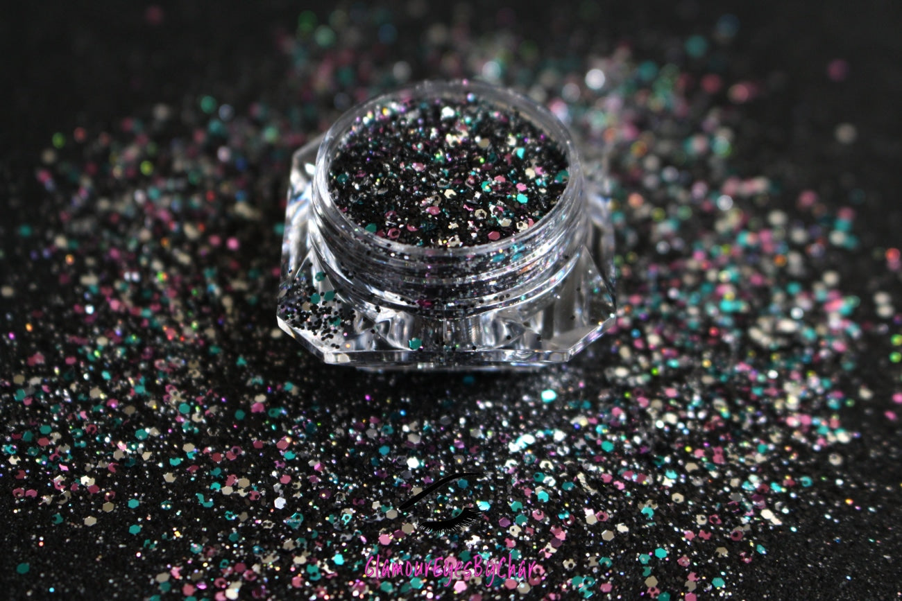 This glitter is called Drama Queen and is part of the chunky glitter collection. It consists of black holographic glitter with a multi-coloured sparkle. Drama Queen can be used for your face, body, hair and nails. Comes in 5g and 10g jars.