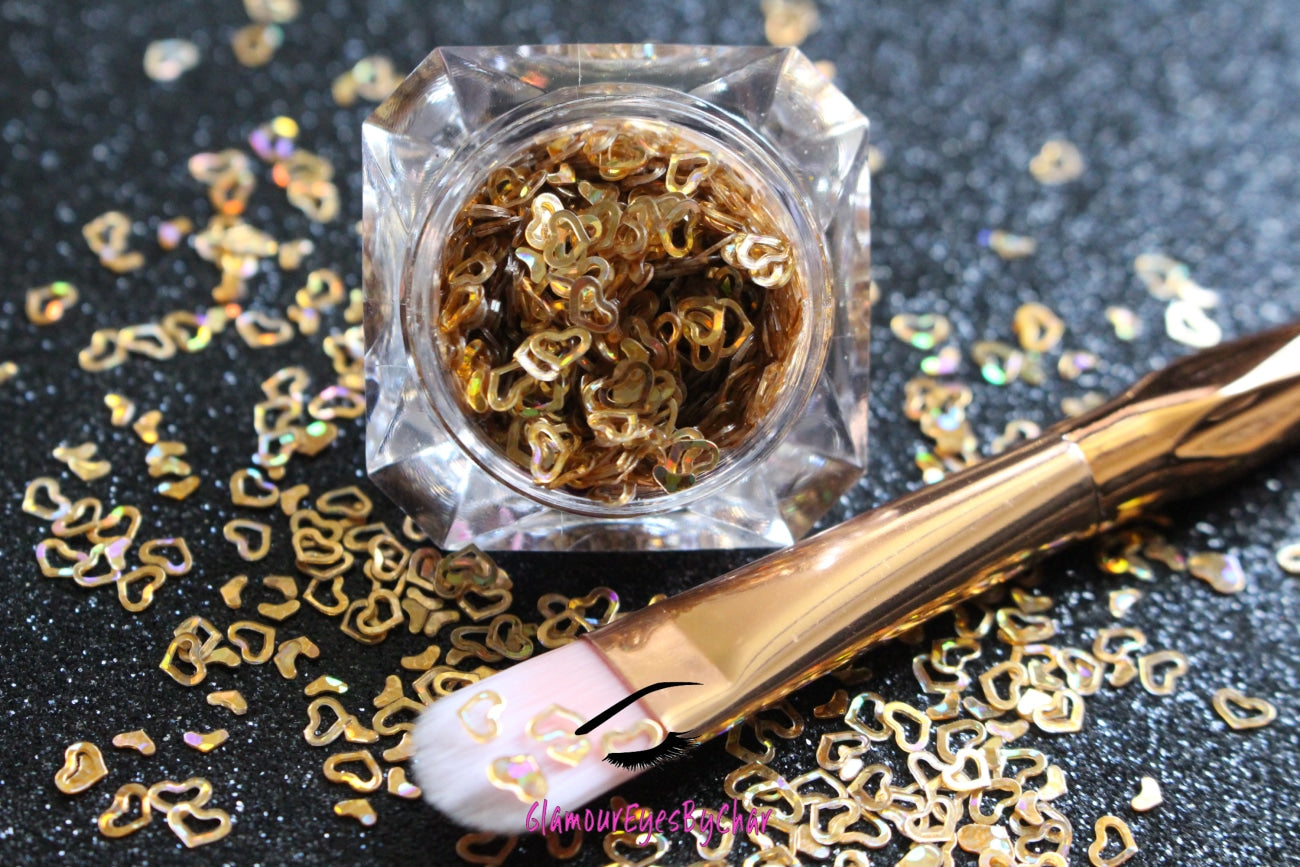 This glitter is called Holographic Gold Hearts and is part of the shaped glitters collection. It consists of gold small and large hearts with a holographic sparkle. Holographic Gold Hearts is perfect for nail and body art.