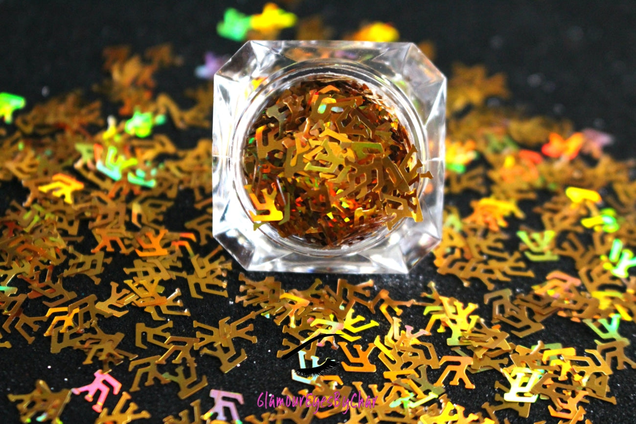 This glitter is called LV and is part of the shaped glitters collection. It consists of unique Louis Vuitton designer inspired holographic gold LV letters. LV can be used for body and nail art or DIY projects. Available in 5g jars only.