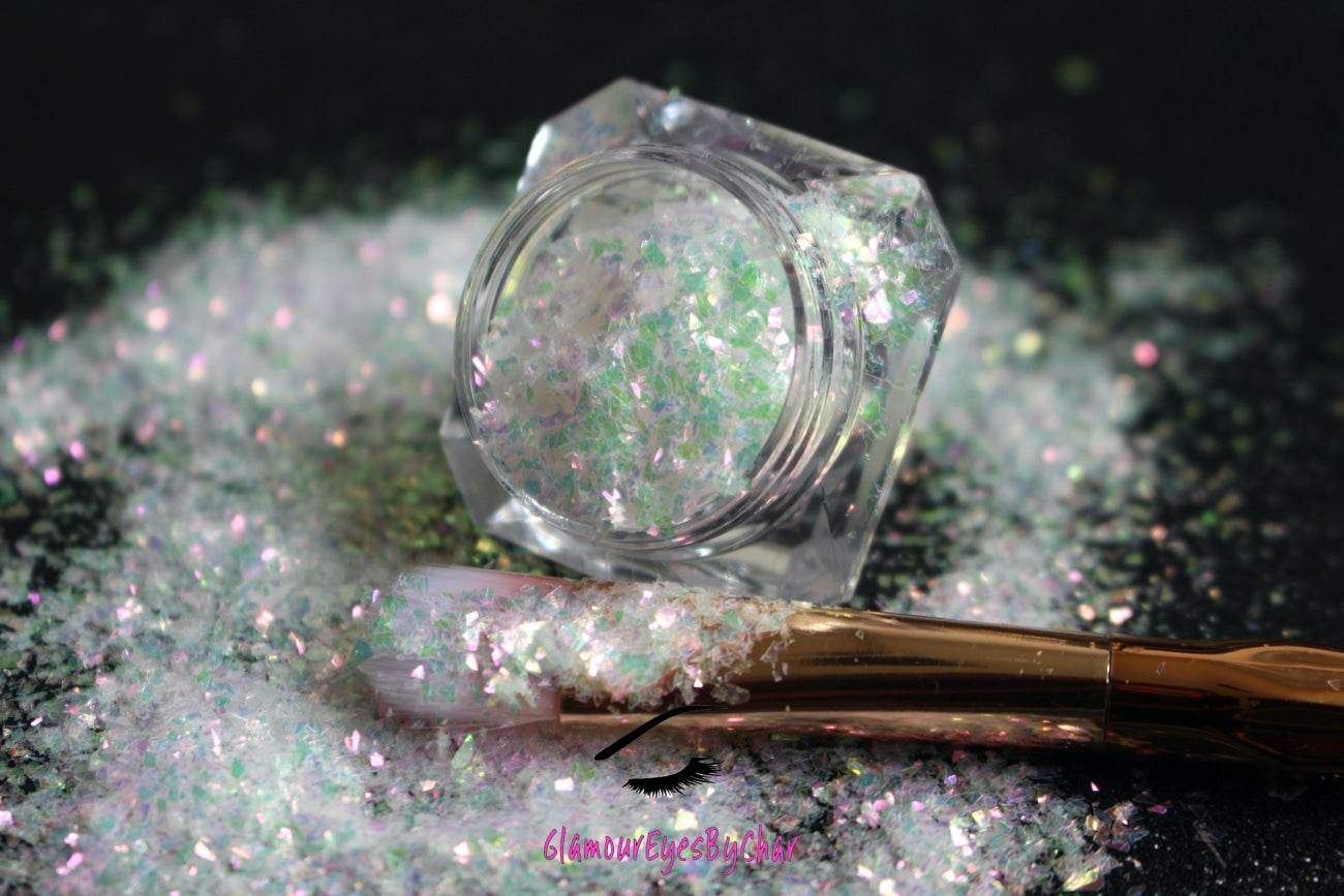 This glitter is called Pink Moscato and is part of the cellophane glitter flakes collection. It consists of white iridescent glitter shards with pink, green and golden reflects. Pink Moscato is perfect for body and nail art, glitter slime, resin art or DIY projects. Comes in 5g jars only.  