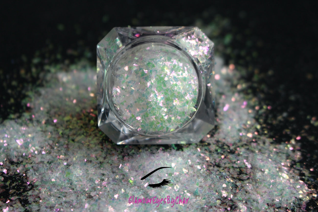 This glitter is called Pink Moscato and is part of the cellophane glitter flakes collection. It consists of white iridescent glitter shards with pink, green and golden reflects. Pink Moscato is perfect for body and nail art, glitter slime, resin art or DIY projects. Comes in 5g jars only.