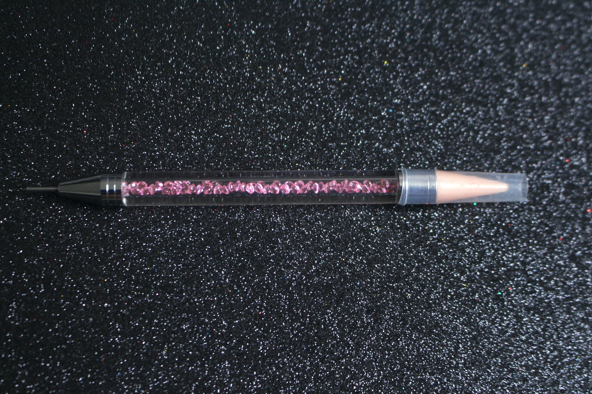 




Crystal Rhinestone Picker – Dual-Ended Tool for Nail Art &amp; DIY
Part of our Glamour Goodies Collection, this crystal dual-ended rhinestone picker is a must-have tool for effortlessly applying rhinestones and beads to nail art or creative DIY projects.

The detachable wax tip helps you easily pick up and place gems, while the stainless steel tip provides precision for more detailed work. Whether you’re working on intricate nail art or creative DIY projects, this tool makes the application process smo