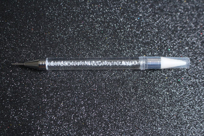 




Crystal Rhinestone Picker – Dual-Ended Tool for Nail Art &amp; DIY
Part of our Glamour Goodies Collection, this crystal dual-ended rhinestone picker is a must-have tool for effortlessly applying rhinestones and beads to nail art or creative DIY projects.

The detachable wax tip helps you easily pick up and place gems, while the stainless steel tip provides precision for more detailed work. Whether you’re working on intricate nail art or creative DIY projects, this tool makes the application process smo