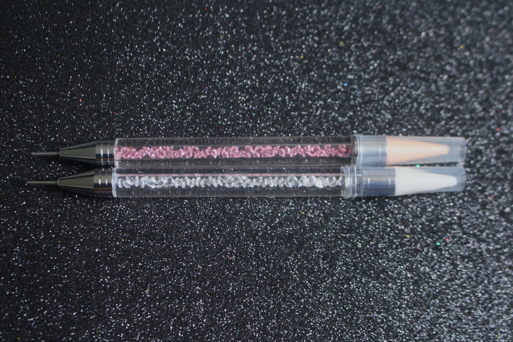 




Crystal Rhinestone Picker – Dual-Ended Tool for Nail Art &amp; DIY
Part of our Glamour Goodies Collection, this crystal dual-ended rhinestone picker is a must-have tool for effortlessly applying rhinestones and beads to nail art or creative DIY projects.

The detachable wax tip helps you easily pick up and place gems, while the stainless steel tip provides precision for more detailed work. Whether you’re working on intricate nail art or creative DIY projects, this tool makes the application process smo