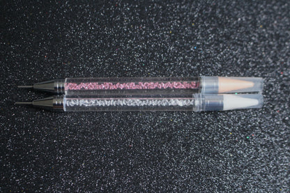 




Crystal Rhinestone Picker – Dual-Ended Tool for Nail Art &amp; DIY
Part of our Glamour Goodies Collection, this crystal dual-ended rhinestone picker is a must-have tool for effortlessly applying rhinestones and beads to nail art or creative DIY projects.

The detachable wax tip helps you easily pick up and place gems, while the stainless steel tip provides precision for more detailed work. Whether you’re working on intricate nail art or creative DIY projects, this tool makes the application process smo