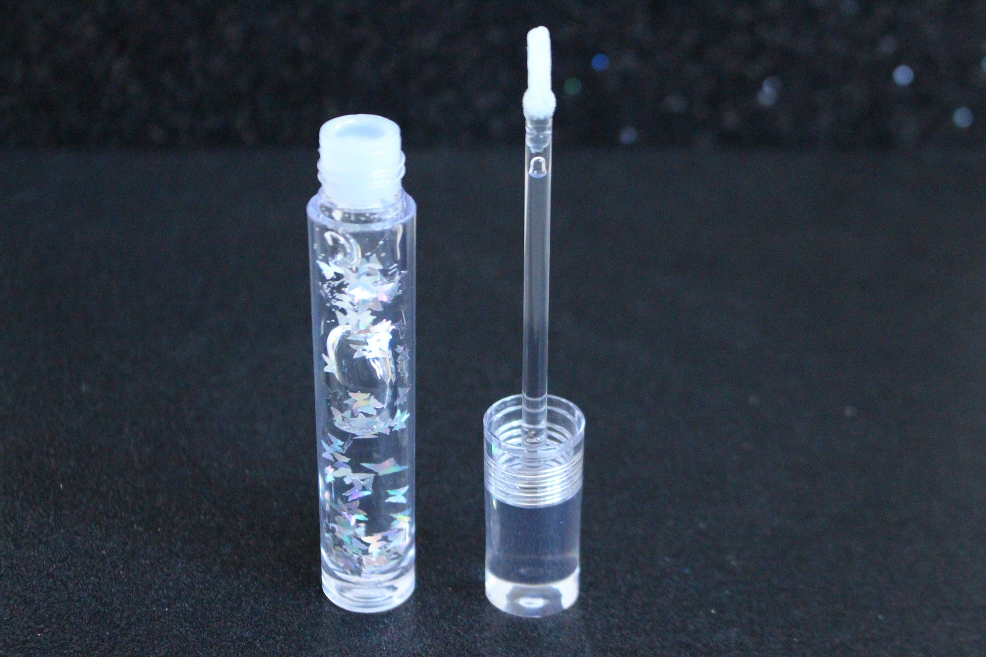 Crystal Clear is a clear handmade hydrating gloss with silver holographic butterflies. This gloss is also vegan, cruelty-free, gluten-free, high shine, smooth and long lasting. It's made with premium rich ingredients to keep your lips soft, moisturized and luscious without feeling sticky. Crystal Clear is available in a squeeze tube and a wand tube (flat doe foot applicator) for a more precise application.