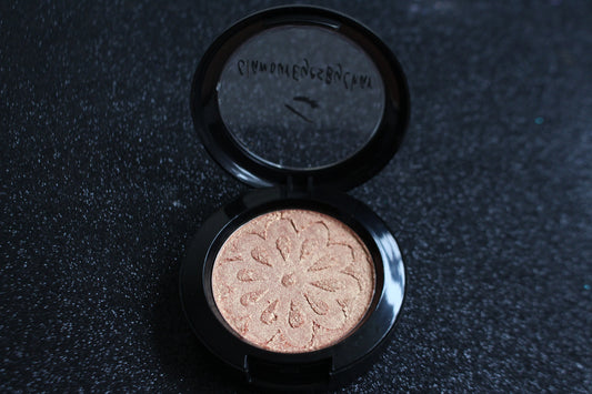 Nefertiti Glamlighter – Light Golden with Warm Orange Hues
Part of our Glamour Goodies Collection, the Nefertiti Glamlighter channels the glow of a goddess with its light golden shade kissed with warm orange tones. Perfect as a highlighter or eyeshadow, Nefertiti is made for bold glow lovers, and trust us, a little goes a long way!

Our handmade pressed glamlighter is richly pigmented and silky smooth, gliding effortlessly onto your skin for a luminous, eye-catching glow. The buttery formula builds and blen