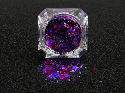 Deep purple and violet super chunky glitter mix with holographic sparkle spilled from a clear jar onto a black textured background.