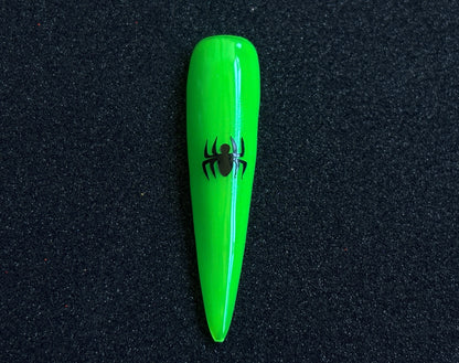 Black spider nail sticker applied on a bright green stiletto nail tip against a black textured background.
