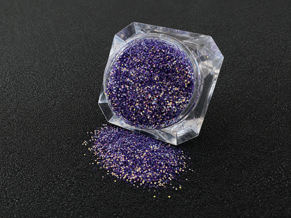 Purple and gold glitter mix spilled from a clear jar onto a black textured background.