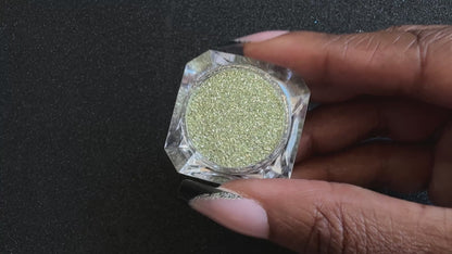 Champagne gold and silver glitter mix in a clear jar, tilted back and forth to show sparkle against a black background.