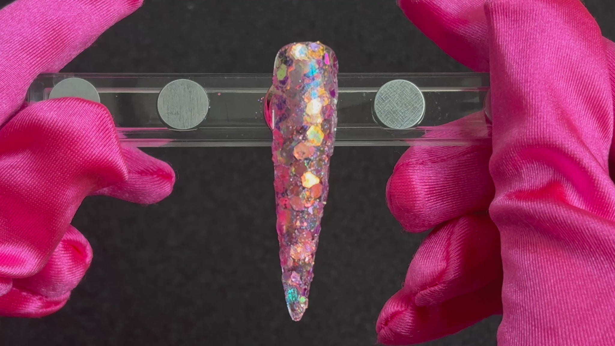 Super chunky pastel purple glitter mix with rose gold iridescent colour shift applied on a stiletto nail tip, tilted to show sparkle.