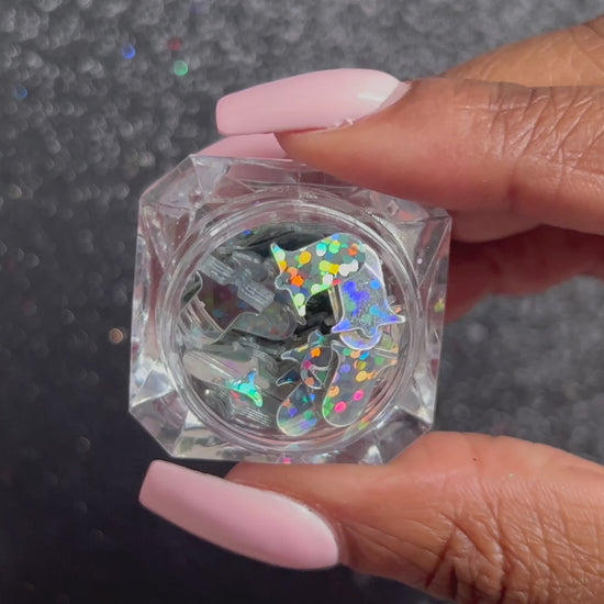 Silver Bells – Premium 10mm Holographic Glitter Shapes
Part of our Holiday Collection, these shimmering 10mm silver bells add a joyful sparkle to nail art and glitter slime.
Available in 5g jars only.