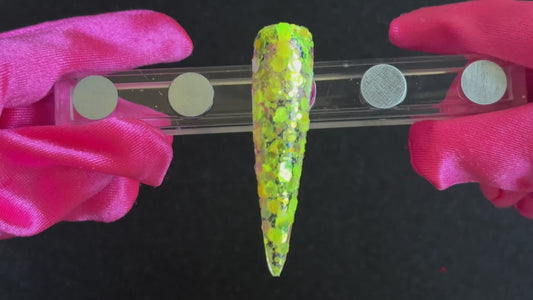 Fluorescent iridescent green super chunky glitter mix with yellow shift applied on a stiletto nail tip, tilted back and forth to show sparkle.