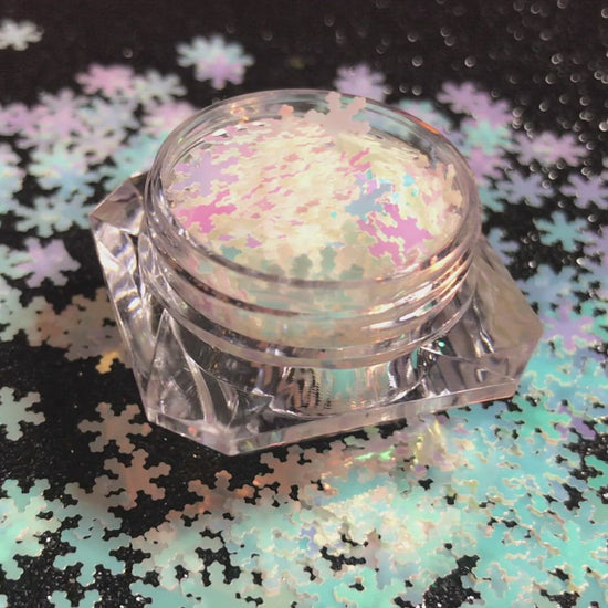 This glitter is called White Snowflakes and is part of the holiday collection.  It consists of white 6mm snowflakes with a light blue and pink iridescent sparkle. White Snowflakes can be used for body and nail art or DIY projects. Comes in 5g jars only.