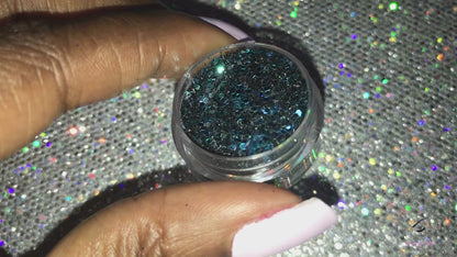 This glitter is called Pure Poison and is part of the chunky glitter collection. It consists of black holographic glitter with a teal and aqua sparkle. Pure Poison can be used for your face, body, hair and nails.  Comes in 5g and 10g jars. **Glitter will be discontinued once sold out**