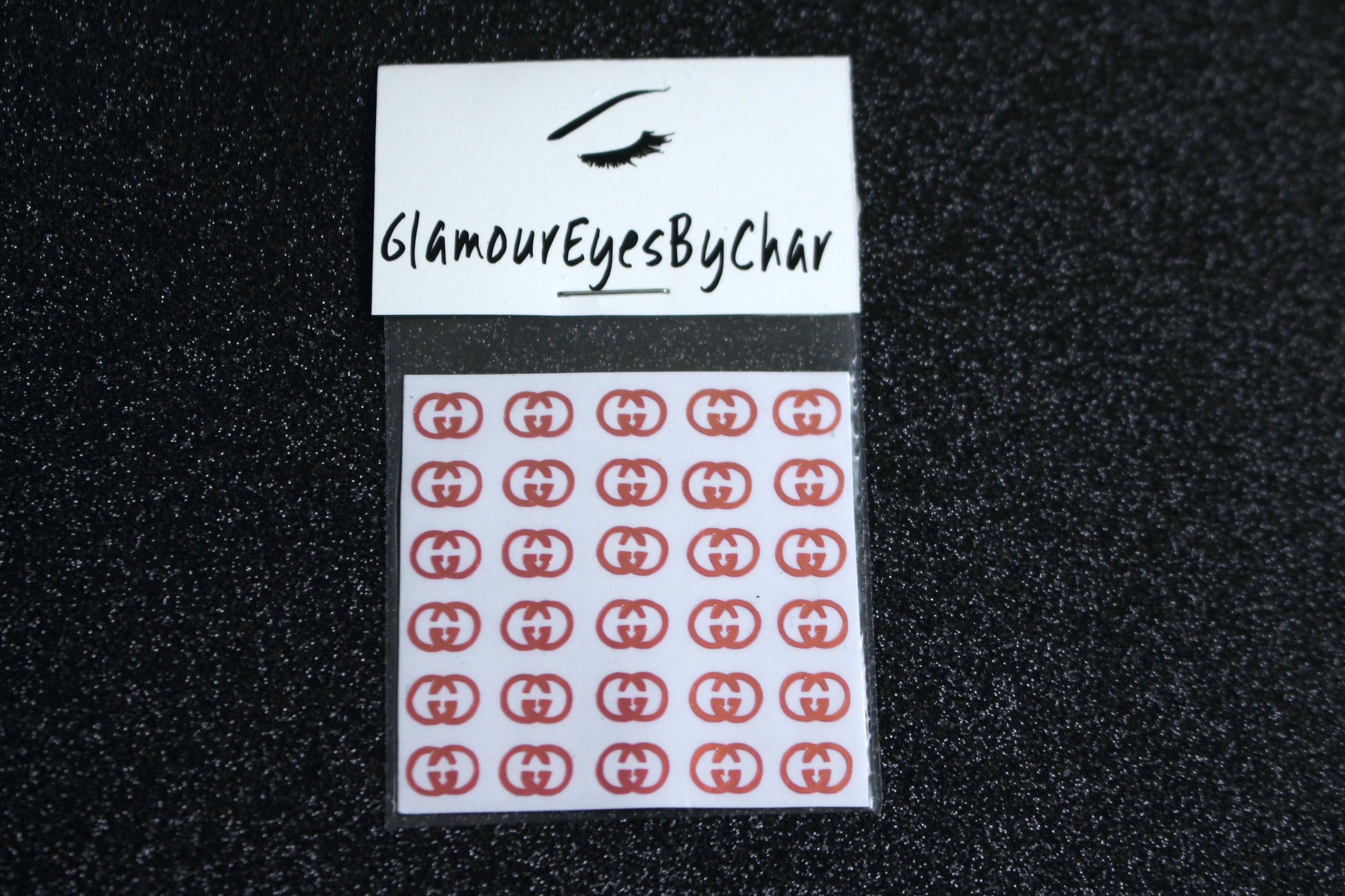Spice up your nails with these unique GG designer inspired nail decals. They can be used on natural or acrylic nails. You can also apply them on top of regular or gel/shellac nail polish. These handmade decals can also be used for body art or any DIY project. The pack contains 30 decals and is available in 4 different colours.   Size: ﻿W= 0.3 inches, H= 0.22 inches  Tip: Apply some of our glitter on your nails to really GLAMOUREYES your look.