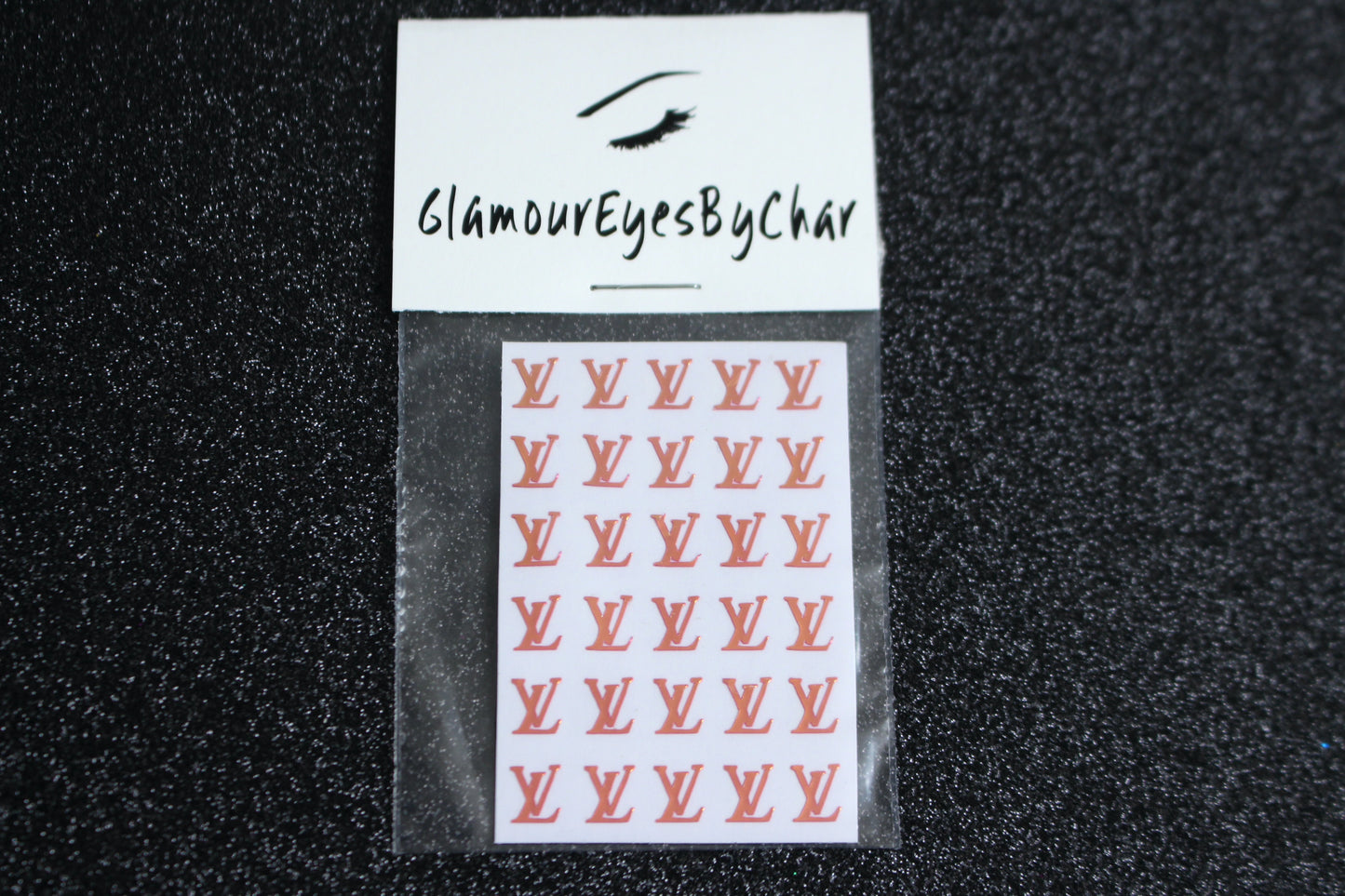 Spice up your nails with these unique LV designer inspired nail decals. They can be used on natural or acrylic nails. You can also apply them on top of regular or gel/shellac nail polish. These handmade decals can also be used for body art or any DIY project. The pack contains 30 decals and is available in 4 different colours.   Size: ﻿W= 0.21 inches, H= 0.252 inches  Tip: Apply some of our glitter on your nails to really GLAMOUREYES your look.