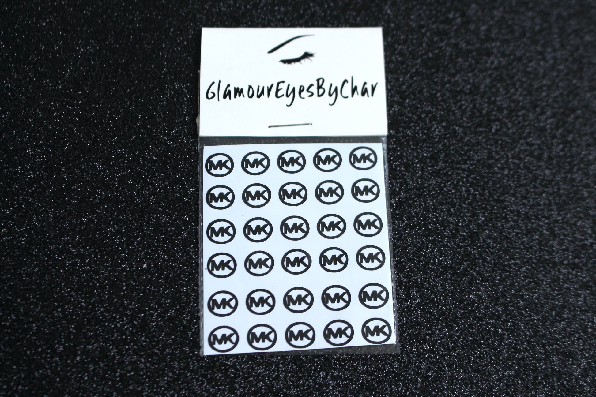 Spice up your nails with these unique MK designer inspired nail decals. They can be used on natural or acrylic nails. You can also apply them on top of regular or gel/shellac nail polish. These handmade decals can also be used for body art or any DIY project. The pack contains 30 decals and is available in 4 different colours.   Size: ﻿W= 0.323 inches, H= 0.297 inches  Tip: Apply some of our glitter on your nails to really GLAMOUREYES your look.  