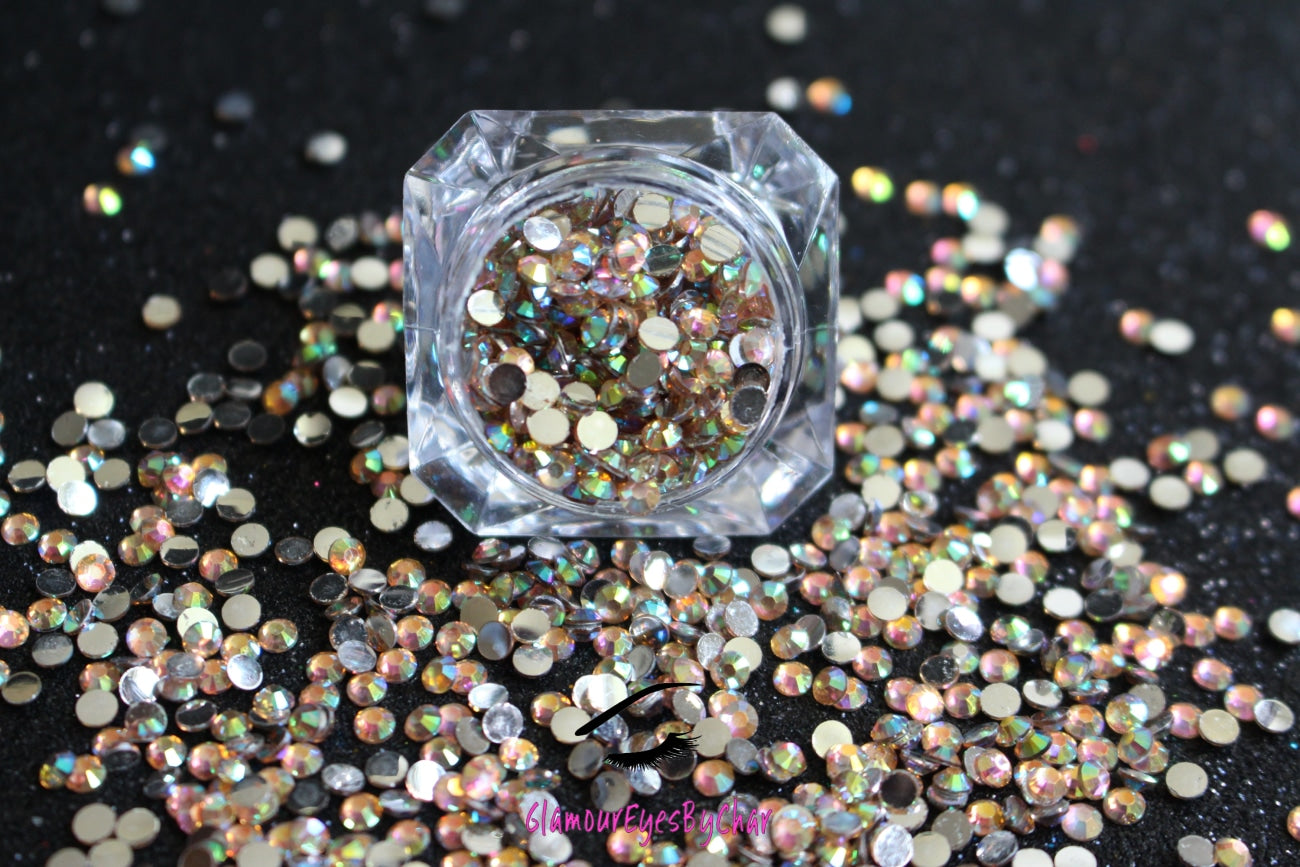 Spice up your nails or makeup look with these champagne AB flatback resin rhinestones.  Stone size: 2mm and 3mm Available in 5g and 10g jars.  Note: 10g jars are round and not diamond shaped. Rhinestones are not counted individually and go by the weight of the jar.