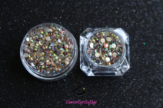 Spice up your nails or makeup look with these champagne AB flatback resin rhinestones.  Stone size: 2mm and 3mm Available in 5g and 10g jars.  Note: 10g jars are round and not diamond shaped. Rhinestones are not counted individually and go by the weight of the jar.