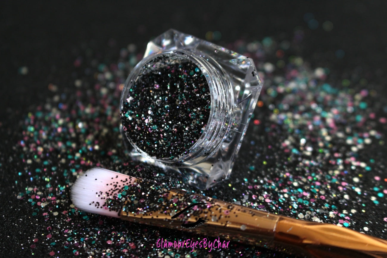 This glitter is called Drama Queen and is part of the chunky glitter collection. It consists of black holographic glitter with a multi-coloured sparkle. Drama Queen can be used for your face, body, hair and nails.  Comes in 5g and 10g jars.