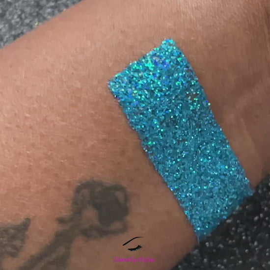 This glitter is called Poolside and is part of the simple glitter collection. It consists of caribbean sea blue glitter with a holographic sparkle.  Poolside can be used for your face, body, hair and nails. Available in 5g jars only.