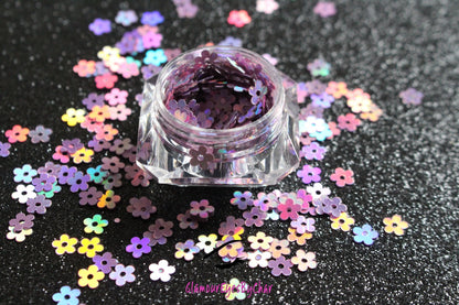 This glitter is called Lilac Holographic Flowers and is part of the shaped glitters collection. It consists of lilac flowers with a holographic sparkle. Lilac Holographic Flowers is perfect for nail and body art.