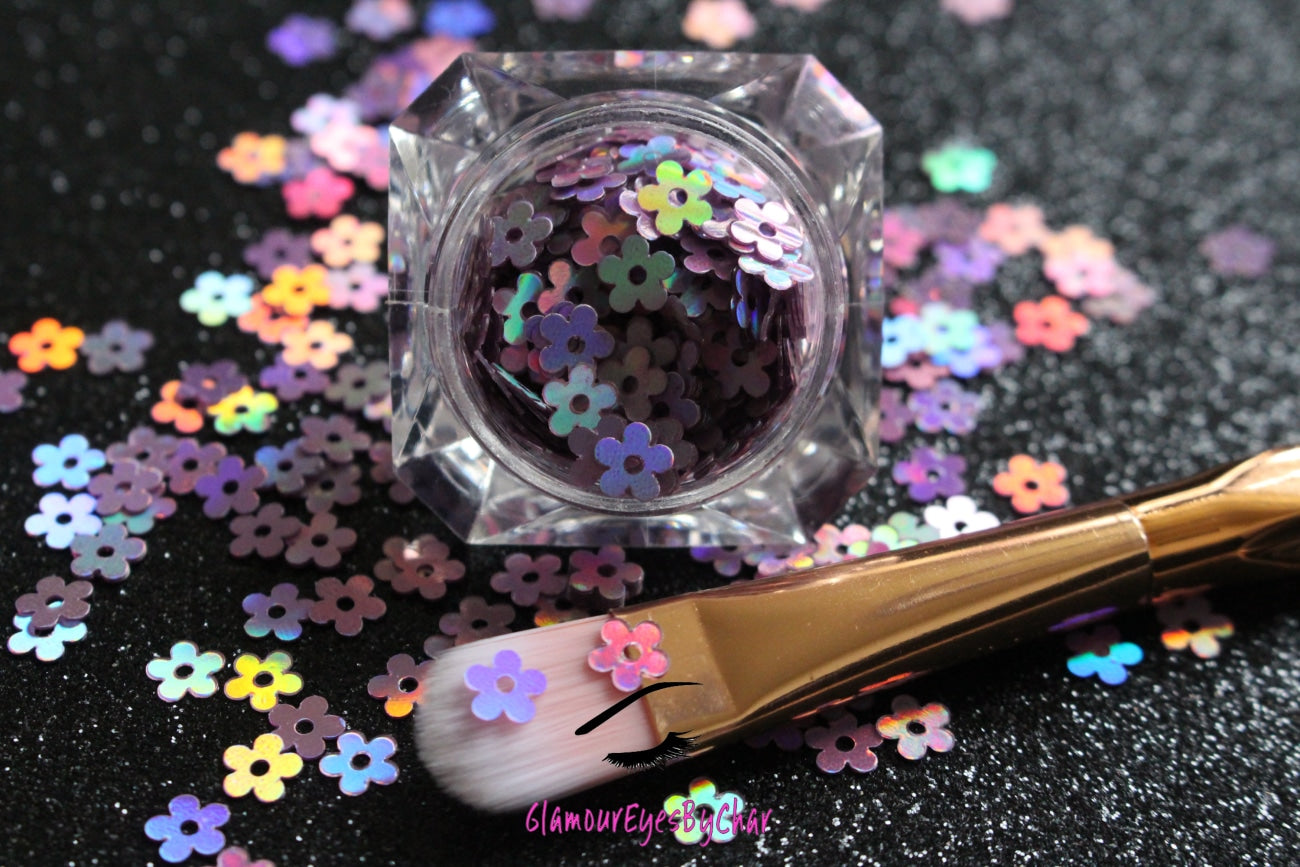 This glitter is called Lilac Holographic Flowers and is part of the shaped glitters collection. It consists of lilac flowers with a holographic sparkle. Lilac Holographic Flowers is perfect for nail and body art.