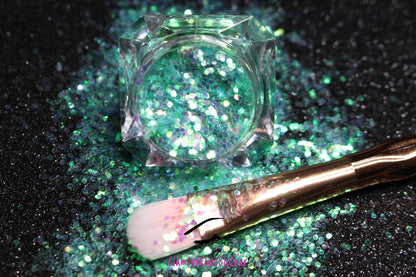 This glitter is called Sea Me and is part of the simple glitter collection. It consists of aqua green glitter with an iridescent sparkle. Flake size is larger than fine and extra fine glitter. Sea Me can be used for your face, body, hair and nails.