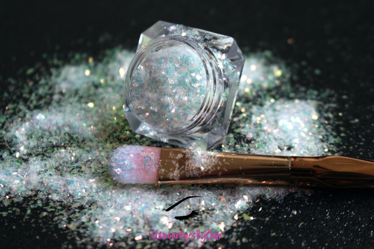 This glitter is called Shimmer and is part of the cellophane glitter flakes collection. It consists of white iridescent glitter shards with golden reflects. Shimmer is perfect for body and nail art, glitter slime, resin art or DIY projects. Comes in 5g jars only.  