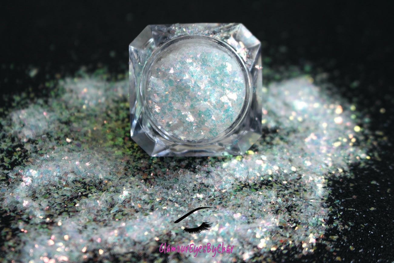 This glitter is called Shimmer and is part of the cellophane glitter flakes collection. It consists of white iridescent glitter shards with golden reflects. Shimmer is perfect for body and nail art, glitter slime, resin art or DIY projects. Comes in 5g jars only.  