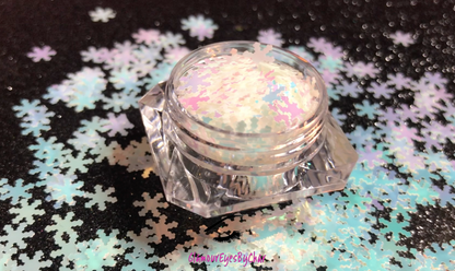 This glitter is called White Snowflakes and is part of the holiday collection.  It consists of white 6mm snowflakes with a light blue and pink iridescent sparkle. White Snowflakes can be used for body and nail art or DIY projects. Comes in 5g jars only.  